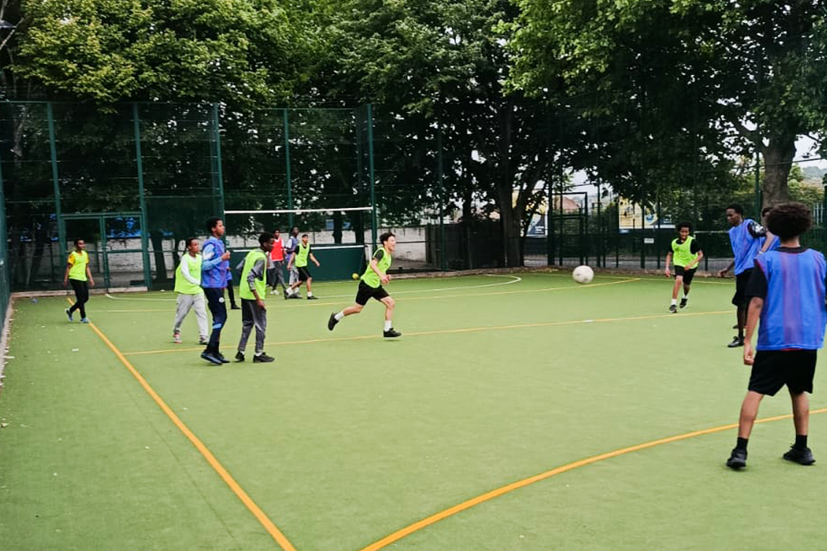 Young people playing football on the community pitch
